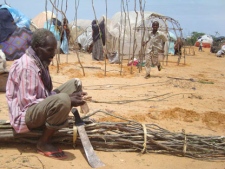 A Somali man from southern Somalia cuts tree branches to construct a makeshift shelter in refugee camp in Mogadishu, Somalia, Thursday Aug. 11, 2011. The United Nations estimates that tens of thousands of people have died from malnutrition in Somalia in recent months, and over 11 million people across East Africa need food aid because of a long-running drought. (AP Photo/Farah Abdi Warsameh)