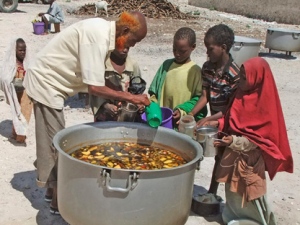 Somali children from southern Somalia, receive cooked food in Mogadishu, Somalia, Monday, Aug 15, 2011. The World Food Program said Saturday that it is expanding its food distribution efforts in famine-struck Somalia, where the U.N. estimates that only 20 percent of people needing aid are getting it.(AP Photo/Farah Abdi Warsameh)