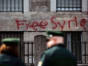 German police officers patrol in front of the vandalized Syrian embassy in Berlin, Tuesday, Aug. 23, 2011. Police say vandals threw scores of red paint bombs on Monday at the Syrian Embassy in downtown Berlin and scrawled "Free Syria" on its facade. Syrian President Bashar Assad has tried in vain to crush a five-month-old uprising against his rule. About 2,200 people have died as a result of the crackdown, with 350 reportedly killed since the beginning of the month. (Photo/Markus Schreiber)