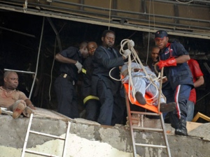 A injured man is carried from a United Nation's office after a car blew up in Abuja, Nigeria, Friday, Aug. 26, 2011. A car laden with explosives rammed through two gates and blew up at the United Nations' offices in Nigeria's capital Friday, killing at least seven people and shattering part of the concrete structure. (AP Photo)