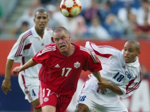 Canada's Ian Hume (17) is held as he competes for the ball against Cuba's Alain Cervantes (18) while Cuba's Silvio Pedro Minoso (4) watches from behind during Gold Cup action at Gillette Stadium in Foxboro, Mass. Monday, July 14, 2003. (AP Photo/Winslow Townson)