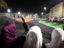 Women celebrate the revolution against Moammar Gadhafi's regime and ask for more women's rights, as they hols a pre-Gadhafi's flag in Tripoli, Libya, Friday, Sept. 2, 2011. Rebel forces are advancing toward Moammar Gadhafi's hometown Sirte despite the extension of a deadline for the town's surrender, rebel officials said Friday, as a U.N. official warned that Libya faces critical but short-term shortages of drinking water, food and other supplies. (AP Photo/Alexandre Meneghini)