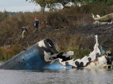 Rescuers are seen at the crash site of Russian Yak-42 jet near the city of Yaroslavl on the Volga River, about 150 miles (240 kilometres) northeast of Moscow, Russia on Wednesday, Sept. 7, 2011. The Yak-42 jet was carrying the Lokomotiv ice hockey team from Yaroslavl. (AP Photo/Misha Japaridze)