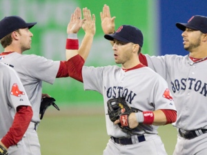 Boston Red Sox's Marco Scutaro, centre, celebrates with teammates Jed Lowrie, left, and Mike Aviles following the Red Sox's 14-0 victory over the Toronto Blue Jays during MLB baseball action in Toronto Tuesday, September 6, 2011. (THE CANADIAN PRESS/Darren Calabrese)