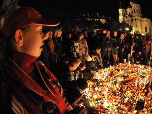 People gather next to the burning candles at Old Town Square in Prague, Czech Republic, to pay tribute to the Lokomotiv Yaroslavl players including three Czech players killed in the plane crash in the city of Yaroslavl, in Minsk, Belarus, on Wednesday, Sept. 7, 2011. The Yak-42 jet carrying the Lokomotiv ice hockey team crashed while taking off Wednesday near Yaroslavl, on the Volga River about 150 miles (240 kilometers) northeast of Moscow, Russia. (AP Photo/CTK, Michal Dolezal)