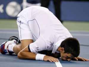 Novak Djokovic of Serbia kisses the court after winning the men's championship match against Rafael Nadal of Spain at the U.S. Open tennis tournament in New York, Monday, Sept. 12, 2011. (AP Photo/Charles Krupa) 