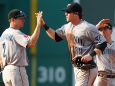 Toronto Blue Jays' Adam Loewen, center, gets a high-five from Kelly Johnson, left, and a pat on the back from Mike McCoy after the Blue Jays beat the Boston Red Sox 5-4 in a baseball game at Fenway Park in Boston, Wednesday Sept. 14, 2011. Loewen's two-run single in the eighth inning put the Jays ahead for the win. (AP Photo/Charles Krupa)