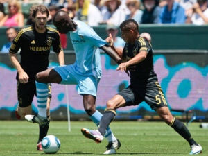 Manchester City forward Mario Balotelli, middle, controls the ball as he is defended by Los Angeles Galaxy's Sean Franklin, right, and Kyle Davies during the first half of a friendly soccer match, Sunday, July 24, 2011, in Carson, Calif. Manchester City won 7-6 on penalty kicks after a 1-1 draw. (AP Photo/Bret Hartman)