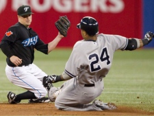 Toronto Blue Jays' Mike McCoy, left, tags out New York Yankees' Robinson Cano in the second inning of MLB baseball action in Toronto Friday, September 16, 2011. (THE CANADIAN PRESS/Darren Calabrese)