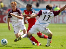 Toronto FC 's Julian de Guzman (centre) takes the ball past Colorado Rapids' Jeff Larentowicz (left) and Brian Mullan during first half MLS action in Toronto on Saturday September 17, 2011. THE CANADIAN PRESS/Chris Young