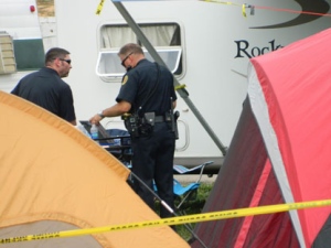 Clarksville Police survey the trailer where five people were found dead Sunday, Sept. 18, 2011 in Clarksville, Tenn., at the Clarksville Speedway. The deaths brought an abrupt halt to the celebration of the state's largest toy run for needy children, which was hosted Saturday at the speedway by Bikers Who Care. (AP Photo/The Leaf-Chronicle, Luke Thomspson)