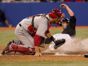 Toronto Blue Jays Mike McCoy (right) steals home plate in front of Los Angeles Angels catcher Jeff Mathis to score the game winning run during the tenth inning of MLB baseball action in Toronto on Monday September 19, 2011. (THE CANADIAN PRESS/Chris Young)