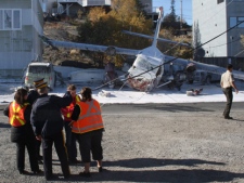 Emergency workers attend the scene of a plane crash in Yellowknife on Thursday Sept. 22, 2011. The plane, an Arctic Sunwest Charters Twin Otter, which was equipped to land on water, went down in a part of town near Great Slave Lake. It crashed near the float plane docks, not far from the Bush Pilot's Monument. (THE CANADIAN PRESS/John Doody)