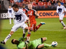 Pumas Unam Kevin Quinones (left) stumbles over Toronto FC goalie Milos Kocic (left) while driving to the net during their CONCACAF Champions League match in Toronto on Tuesday September 27, 2011. (THE CANADIAN PRESS/Aaron Vincent Elkaim)