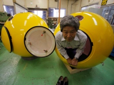 Cosmo Power Co. President Shoji Tanaka crawls out from a spherical earthquake and tsunami shelter "Noah" made of fiber enforced plastic at the company's factory in Hiratsuka, west of Tokyo, Friday, Sept. 30, 2011. The Japanese generator maker has developed a modern version of Noah's Ark in case Japan is hit by another massive earthquake and tsunami. The company of just 10 employees completed the first Noah, that has 1.2 meters (4 feet) in diameter and can hold up to four adults inside, earlier this month and already has 500 orders. (AP Photo/Itsuo Inouye)