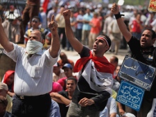 Egyptian demonstrators chant slogans as they attend a protest at Tahrir Square in Cairo, Egypt Friday, Sept. 30, 2011. Several thousand Egyptians are protesting against the country's military rulers decision to retain the much hated emergency laws used throughout the reign of ousted President Hosni Mubarak to give police almost unquestionable powers to operate. The sign at right reads in Arabic: "Shaab Street" and "Shaab and Shura Square for the 25th Jan. revolution" and translates as "People Street" and "The people and the Upper house of Parliament Square for the 25 Jan revolution" (AP Photo/Khalil Hamra)