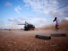 Revolutionary fighters fire a weapon in Sirte, Libya, Friday, Sept. 30, 2011. (AP Photo/Manu Brabo)