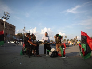 Diver Mohammed Zintani, 40, center, chats with a street vendor at Tripoli's main square, Libya, Monday, Oct. 3, 2011. (AP Photo/Alexandre Meneghini)