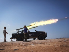 Libyan revolutionary fighters launch a missile during an attack for the city of Sirte, Libya, Wednesday, Oct. 5, 2011. Rebels use tanks and heavy artillery towards loyalist positions inside the home town of Libya's ousted leader Moammar Gadhafi. (AP Photo/Manu Brabo)