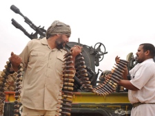 Libyan revolutionary fighters load their machine gun during an attack against pro-Gadhafi forces in Sirte, Libya, Friday, Oct. 7, 2011. Rebel forces have besieged Sirte since September 15 but have not managed to penetrate the heart of the city because of fierce resistance from loyalists inside the home town of Libya's ousted leader Moammar Gadhafi. (AP Photo/Bela Szandelszky)