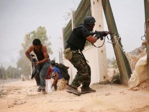 Libyan revolutionary fighters fire toward pro-Gadhafi forces in Sirte, Libya, Saturday, Oct. 8, 2011. Rebel forces have besieged Sirte since mid September, but have not managed to penetrate the heart of the city because of fierce resistance from loyalists inside the home town of Libya's ousted leader Moammar Gadhafi. (AP Photo/Manu Brabo)