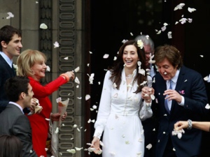 American broadcast journalist and author Barbara Walters throws rose petals as former Beatle Sir Paul McCartney and his wife American heiress Nancy Shevell leave Marylebone Registry Office, following their wedding in central London , Sunday Oct. 9, 2011. Shevell, 51, is McCartney's third wife.The couple met in the Hamptons in Long Island, New York, shortly after the singer's divorce from Heather Mills in 2008 and they were engaged earlier this year. (AP Photo/Lefteris Pitarakis)