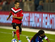 Canada's Josh Simpson (11) is tackled by Puerto Rico's Alexis Rivera (right) during first half World Cup Qualifying action in Toronto on Tuesday October 11, 2011. (THE CANADIAN PRESS/Frank Gunn)