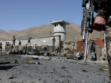 Afghan security forces and US Army soldiers gather at the site of an attack by militants at the gate of an American base in Panjshir north of Kabul, Afghanistan, Saturday, Oct. 15, 2011. Militants tried to blast their way into an American base in eastern Afghanistan on Saturday, striking before dawn with rocket-propelled grenades and a vehicle packed with explosives. All four of the attackers were killed and two Afghan security guards were wounded. (AP Photo/Ahmad Jamshid)