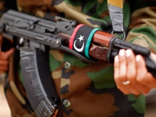 With a Libyan flag on his automatic weapon, a soldier stands guard outside a meeting between U.S. Secretary of State Hillary Rodham Clinton and Libya's Transitional National Council President Mustafa Abdel-Jalil at the World Islamic Call Society Headquarters, during her visit to Tripoli in Libya Tuesday, Oct.18, 2011. (AP Photo / Kevin Lamarque)