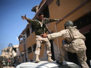 Revolutionary fighters celebrate the capture of Sirte, Libya, Thursday, Oct. 20, 2011. Moammar Gadhafi was killed Thursday when revolutionary forces overwhelmed his hometown, Sirte, the last major bastion of resistance two months after the regime fell. Amid the fighting, a NATO airstrike blasted a fleeing convoy that fighters said was carrying Gadhafi. (AP Photo/Manu Brabo)