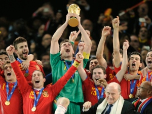 Spain goalkeeper Iker Casillas, center, holds up the World Cup trophy as he and other team members celebrate, as South African President Jacob Zuma, front right, and FIFA president Sepp Blatter, second from right in front, look on during the World Cup final soccer match between the Netherlands and Spain at Soccer City in Johannesburg, South Africa, Sunday, July 11, 2010. (AP Photo/Martin Meissner)