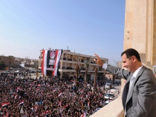 In this photo released by the Syrian official news agency SANA, Syrian President Bashar Assad, right, waves to his supporters after he attended the prayer of Eid Al Adha, at the al-Nour Mosque in the northern town of Raqqa, Syria, on Sunday, Nov. 6, 2011. Syrians in the restive region of Homs performed special prayers for a major Muslim holiday to the sound of explosions and gunfire as government troops pushed forward their assault on the area, killing at least several people Sunday, residents and activists said. (AP Photo/SANA) 