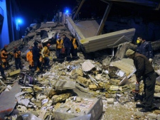 Rescuers search for survivors in the rubble of a collapsed hotel in Van, eastern Turkey, late Wednesday, Nov. 9, 2011. An earthquake struck eastern Turkey on Wednesday night, killing at least three people and leaving dozens trapped in the rubble of toppled buildings damaged in the previous temblor, which had killed 600 people. About 20 buildings collapsed in the provincial capital of Van following a 5.7-magnitude quake, according to media reports.(AP Photo/Evrim Aydin, Anatolia) 