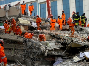 Turkish rescue workers search for survivors in the rubble of a collapsed hotel in Van, Turkey, Friday, Nov. 11, 2011. At least 17 people, including a Japanese aid worker, were killed and dozens of others trapped. The magnitude-5.7 quake was a grim replay of the previous magnitude-7.2 earthquake that hit Oct. 23, killing more than 600 people.(AP Photo/Bertan Ayduk )