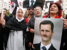 Pro-Syrian regime protesters, shout pro-Syrian President Bashar Assad slogans as they gather outside the Syrian foreign ministry where Syrian Foreign Minister Walid al-Moallem helds a press conference, in Damascus, Syria, on Monday Nov. 14, 2011. Syria's foreign minister accused Arab states on Monday of conspiring against Damascus after the Arab League voted to suspend Syria's membership over the government's deadly crackdown on an eight month-old uprising. (AP Photo/Muzaffar Salman)