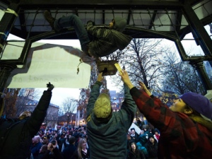 An Occupy Toronto protester climbs a gazebo to hang a union sign as hundreds of union supporters came out to support Occupy Toronto after City of Toronto bylaw officers placed a new batch of eviction notices on tents and structures at the Occupy Toronto grounds in St. James Park in Toronto on Monday, Nov. 21, 2011. (THE CANADIAN PRESS/Nathan Denette)