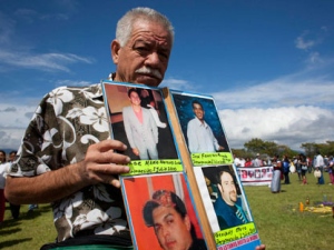 In this photo taken Sept. 12, 2011, Nepomuceno Moreno holds up images of missing people, including his son, top left, during a protest of the Peace Caravan, a civilian anti-crime protest movement, at Monte Alban, in Mexico's Oaxaca state. Moreno, who joined the Peace Caravan after his 18-year-old son disappeared, was shot to death in his hometown in Mexico's northern state of Sonora on Monday, Nov. 28, 2011. Moreno said before his death that he had received repeated threats from the men he believed responsible for kidnapping his son. (AP Photo/Ivan Castaneira)