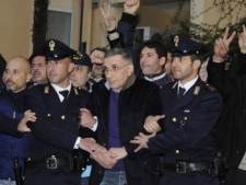 Italian policemen escort fugitive mobster Michele Zagaria, center, at the police headquarters in Naples, Southern Italy, Wednesday, Dec. 7, 2011. Zagaria, on the run since 1995, was arrested Wednesday when he was found by the Italian Police in an underground bunker in Casapesenna, in his hometown province of Caserta in southern Italy, the headquarters of the Casalesi clan of the Neapolitan Camorra. Anti-mafia prosecutor Piero Grasso said it was likely Zagaria had spent his years as a fugitive nearby since mob bosses "can only exercise their power if they're in an environment that protects them." (AP Photo/Salvatore Laporta)