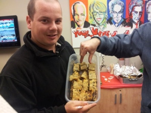 Troy Gallant shows off his fiance's delicious creation while Producer Richard Perry tries to sneak one in.