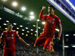 Liverpool's Luis Suarez, right, celebrates with teammate Stewart Downing after scoring a goal against Queens Park Rangers during their English Premier League soccer match at Anfield, Liverpool, England, Saturday Dec. 10, 2011. (AP Photo/Tim Hales)