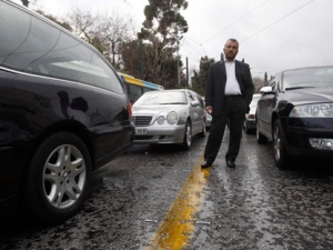A hearse driver stands between empty vehicles during a protest, near the Greek Parliament, in Athens, on Thursday, Dec. 22, 2011. The protesters say their cars have been reclassified as private instead of business vehicles, obliging them to pay up to six times higher rates in road tax by the end of next week for 2012. (AP Photo/Thanassis Stavrakis)