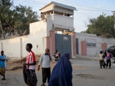 Residents walk outside of the Medecins Sans Frontieres (Doctors Without Borders) compound in Mogadishu, Somalia on Thursday, Dec. 29, 2011. (AP Photo/Mohamed Sheikh Nor)