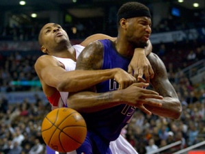 Toronto Raptors' Jamaal Magloire (left) fouls Sacramento Kings' DeMarcus Cousins during the first half NBA action in Toronto on Wednesday, Jan. 11, 2012. (THE CANADIAN PRESS/Pawel Dwulit)