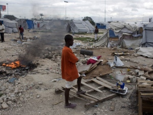 In this Jan. 4, 2012, photo, a boy stands among debris from tents disassembled by authorities who closed a camp occupied by people displaced by the 2010 earthquake near the airport in Port-au-Prince, Haiti. Two years afterwards, more than half a million Haitians are still homeless, and many who have homes are worse off than before the Jan. 12, 2010, quake, as recovery bogs down under a political leadership that has been preoccupied with elections and their messy aftermath. (AP Photo/Dieu Nalio Chery)