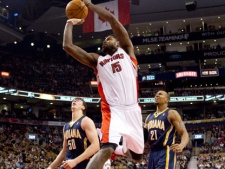 Toronto Raptors' Amir Johnson (centre) scores as Indiana Pacers Tyler Hansbrough (left) and David West look on during first half NBA basketball action in Toronto on Friday, Jan. 13, 2012. (THE CANADIAN PRESS/Chris Young)