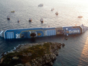 In this photo released by the Guardia di Finanza (border Police), the luxury cruise ship Costa Concordia leans on its side after running aground off the tiny Tuscan island of Giglio, Italy, Saturday, Jan. 14, 2012. The luxury cruise ship ran aground off the coast of Tuscany, sending water pouring in through a 160-foot (50-meter) gash in the hull and forcing the evacuation of some 4,200 people from the listing vessel early Saturday, the Italian coast guard said. The number of dead and injured is not yet confirmed Coast Guard Cmdr. Francesco Paolillo said. (AP Photo/Guardia di Finanza, ho)