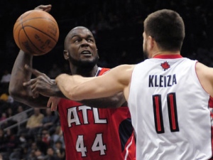 Toronto Raptors forward Linas Kleiza (11) makes contact with Atlanta Hawks forward Ivan Johnson (44) during the first half of an NBA basketball game Monday, Jan. 16, 2012, in Atlanta. (AP Photo/David Tulis)