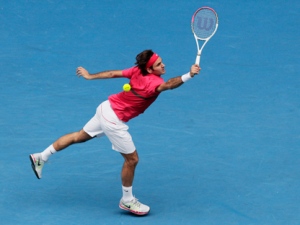 Roger Federer makes a backhand return to Ivo Karlovic during their third round match at the Australian Open tennis championship in Melbourne, Australia on Friday, Jan. 20, 2012. (AP Photo/John Donegan)