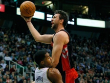 Toronto Raptors forward Andrea Bargnani, top, of Italy, draws a charging foul on Utah Jazz forward Derrick Favors, left, during the first half of their NBA basketball game in Salt Lake City on Wednesday, Jan. 25, 2012. (AP Photo/Steve C. Wilson)