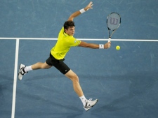 Milos Raonic hits a backhand return to Lleyton Hewitt during their third round match at the Australian Open tennis championship, in Melbourne, Australia, Saturday, Jan. 21, 2012. (AP Photo/Andrew Brownbill)